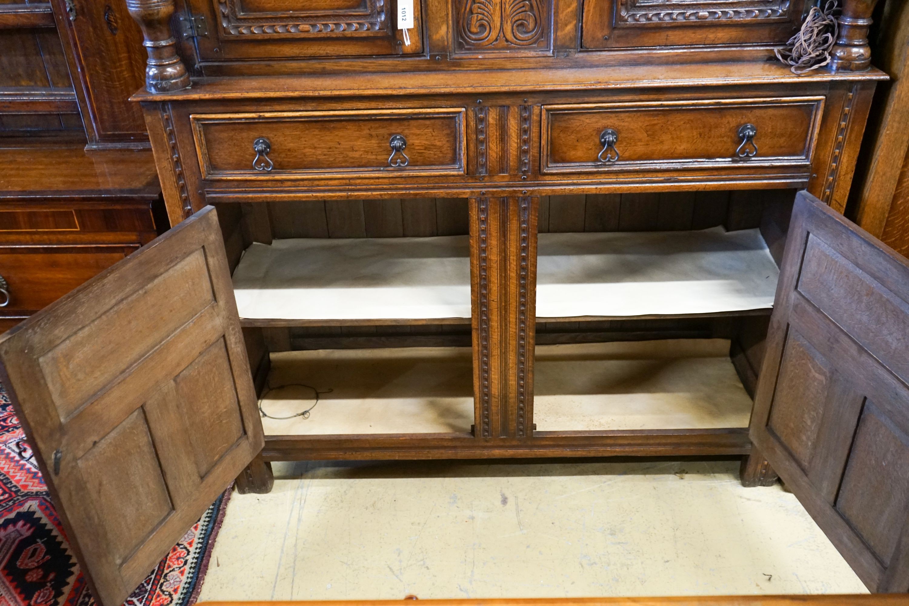 A 17th century style carved and panelled oak court cupboard